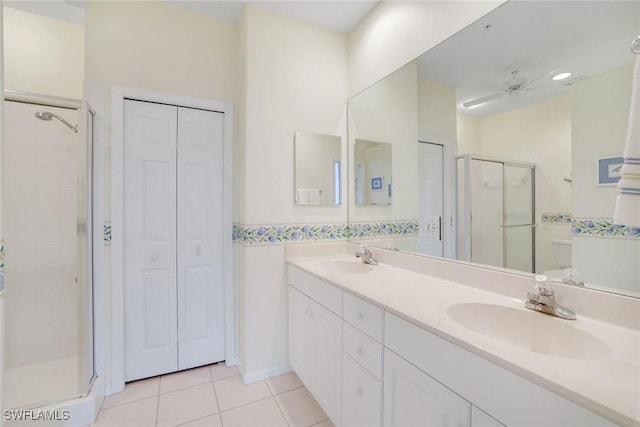 bathroom featuring a closet, tile patterned floors, a sink, and a shower stall