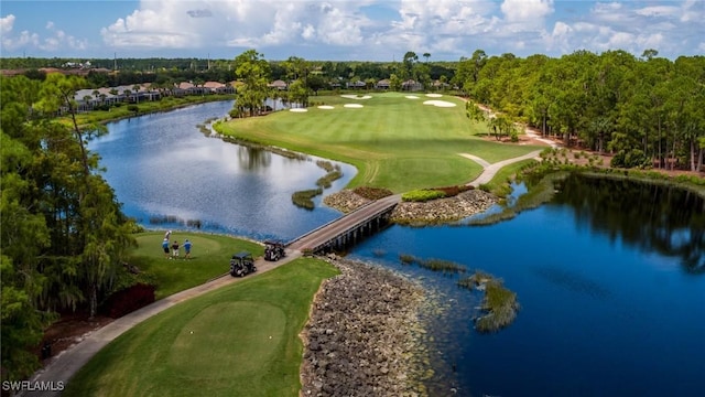 drone / aerial view featuring golf course view and a water view