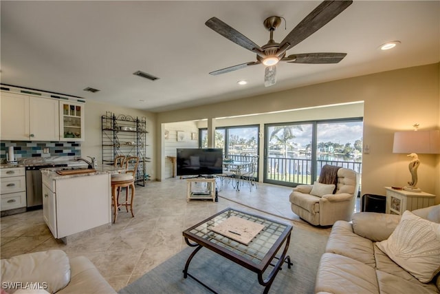 living area with recessed lighting, visible vents, and ceiling fan