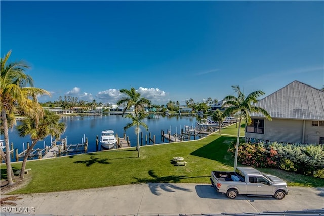 exterior space featuring a water view, boat lift, and a lawn