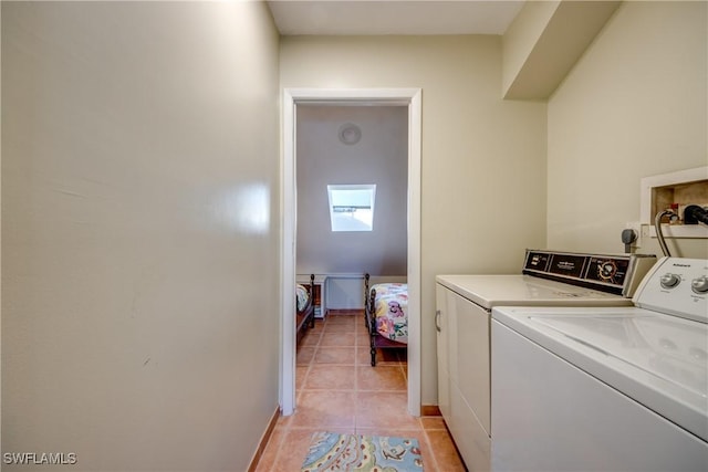 laundry area with light tile patterned floors, laundry area, separate washer and dryer, and baseboards