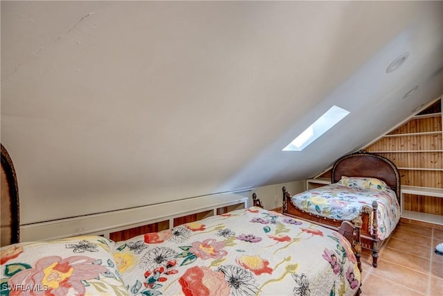 tiled bedroom with vaulted ceiling with skylight and wooden walls