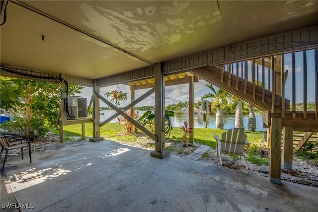 view of patio with ac unit, a water view, and stairway