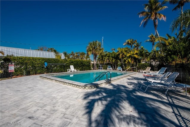 community pool featuring a patio and fence