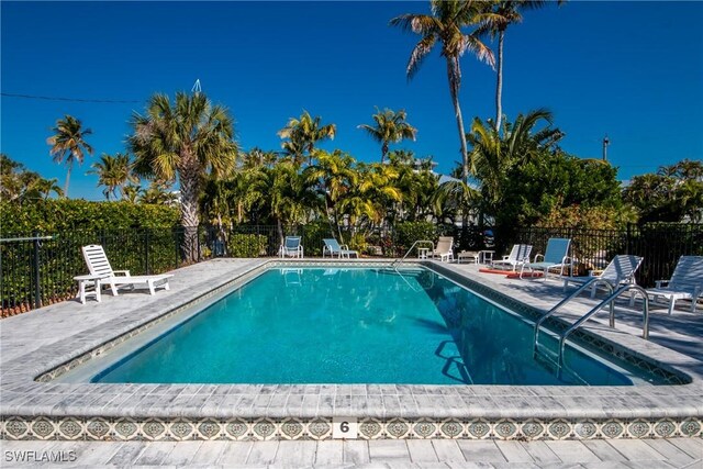 pool with a patio area and fence