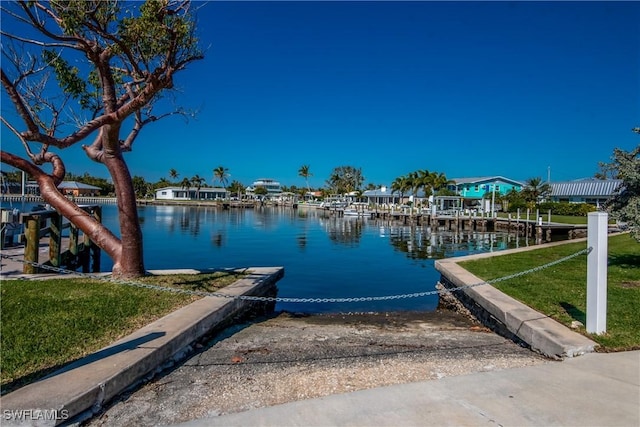 dock area with a water view and a lawn