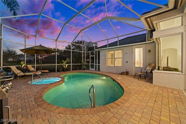 pool at dusk with a patio, a lanai, and a pool with connected hot tub