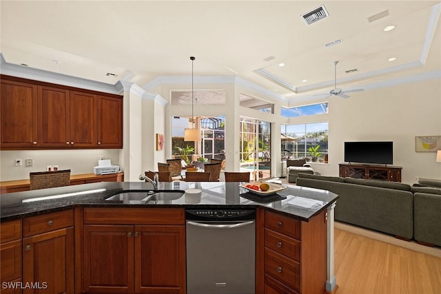 kitchen with ornamental molding, open floor plan, dark stone countertops, light wood-style floors, and a sink