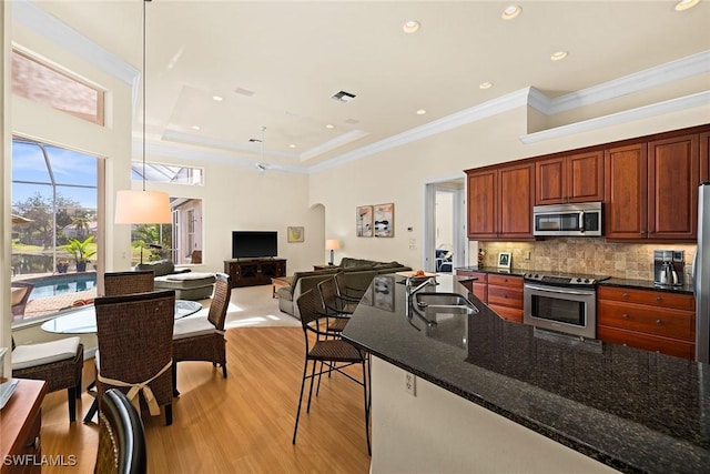 kitchen featuring arched walkways, stainless steel appliances, visible vents, backsplash, and a sink