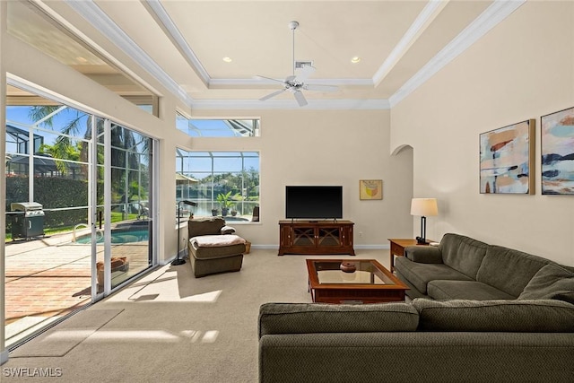 living room with carpet flooring, crown molding, baseboards, and ceiling fan