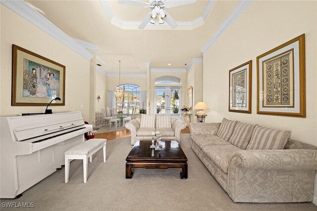 living room with ceiling fan, carpet flooring, ornamental molding, french doors, and a raised ceiling