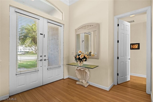 entryway featuring light wood-style floors, french doors, visible vents, and baseboards