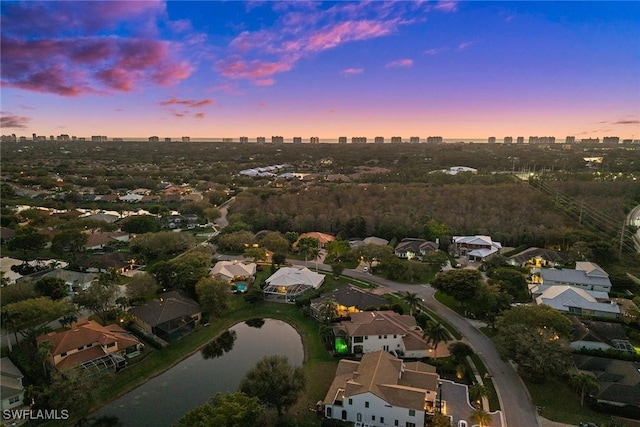 aerial view at dusk with a view of city and a water view