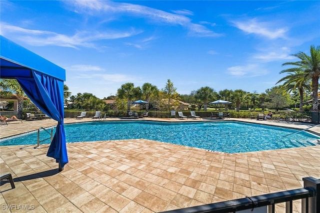 community pool featuring a patio area and fence