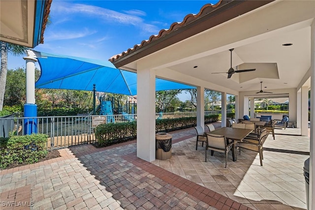 view of patio with ceiling fan, fence, and outdoor dining area