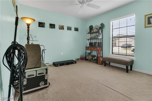 interior space featuring a ceiling fan, carpet flooring, and baseboards