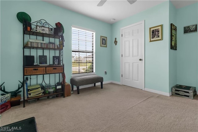 living area featuring carpet, a ceiling fan, and baseboards