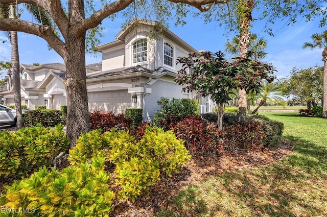 view of property exterior featuring a yard, an attached garage, and stucco siding