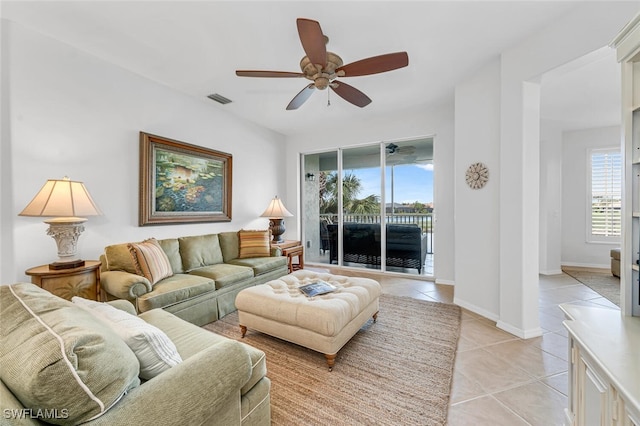 living room with a ceiling fan, visible vents, baseboards, and light tile patterned floors