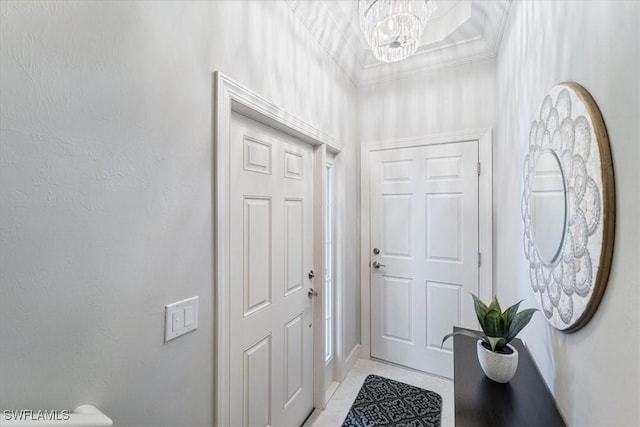 entryway with light tile patterned floors, ornamental molding, and a notable chandelier