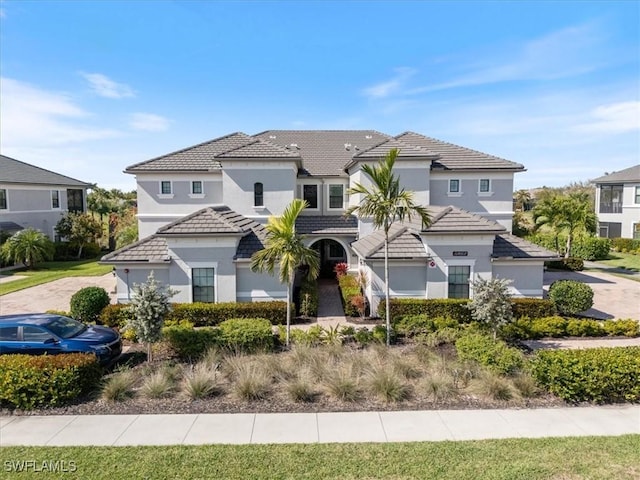 view of front of house with a tiled roof and stucco siding