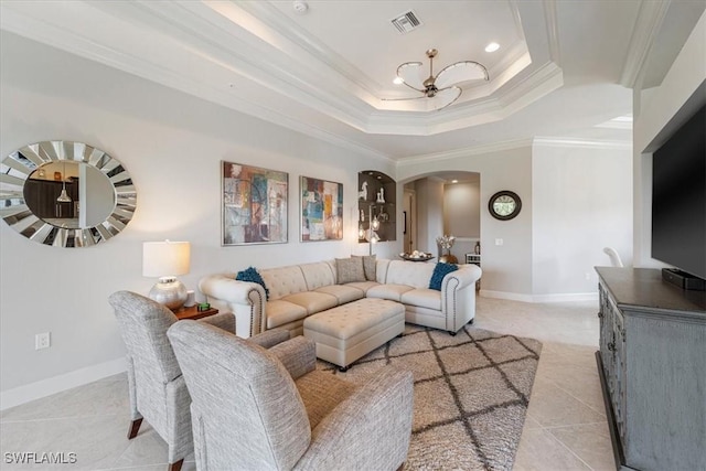 living room featuring arched walkways, a raised ceiling, visible vents, ornamental molding, and baseboards