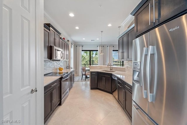 kitchen featuring a sink, light countertops, appliances with stainless steel finishes, hanging light fixtures, and crown molding