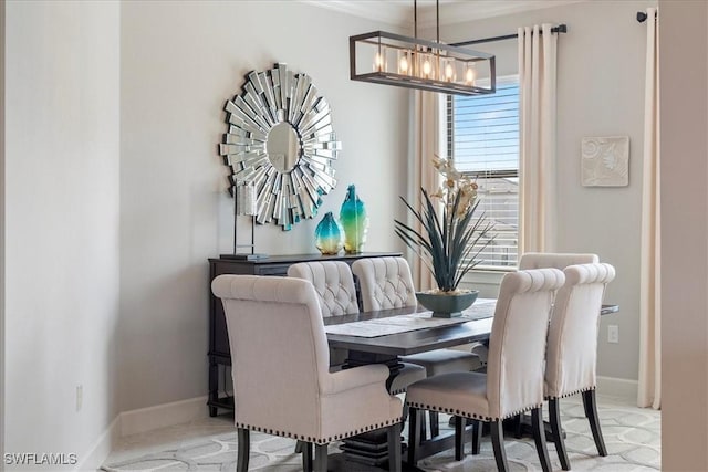 dining space featuring baseboards and a chandelier