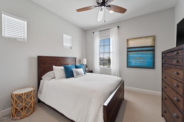 bedroom featuring light carpet, baseboards, and a ceiling fan