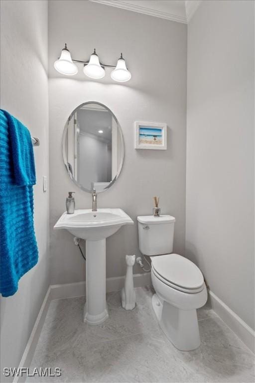 bathroom with crown molding, toilet, and baseboards