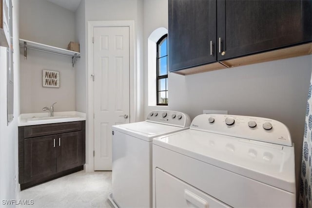 laundry room featuring washer and dryer, cabinet space, and a sink