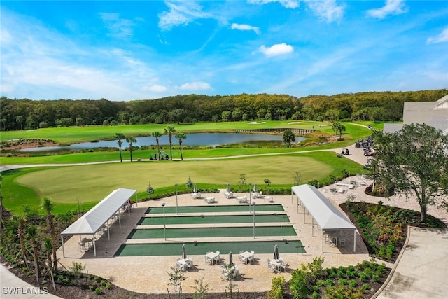 view of property's community featuring view of golf course, a water view, and a lawn