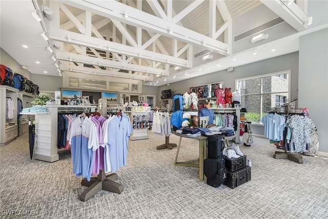 interior space featuring high vaulted ceiling, carpet, visible vents, and baseboards