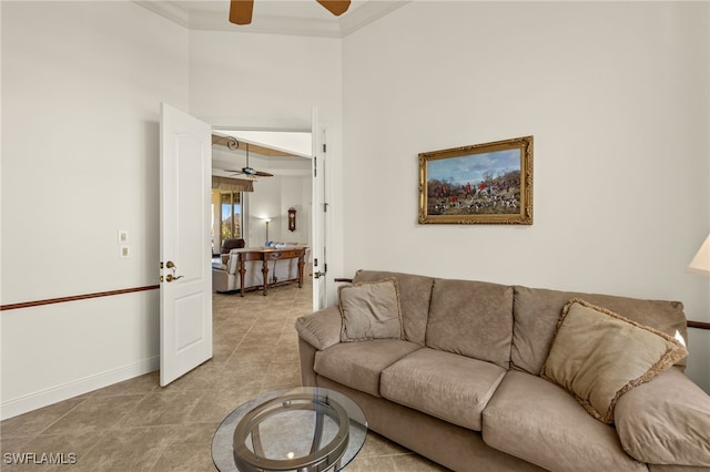 tiled living area with crown molding, a ceiling fan, and baseboards