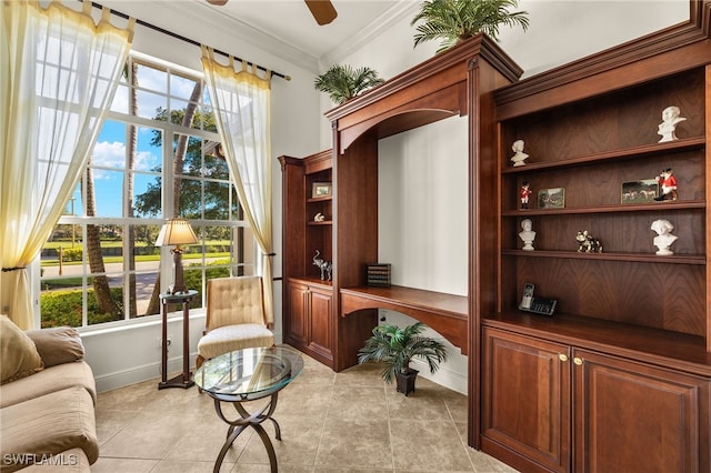 sitting room with ceiling fan, a healthy amount of sunlight, ornamental molding, and built in study area