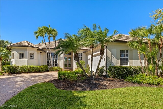 18270 Creekside View Dr, Fort Myers, FL 33908 - view of front facade featuring stucco siding, driveway, a tile roof, french doors, and a garage