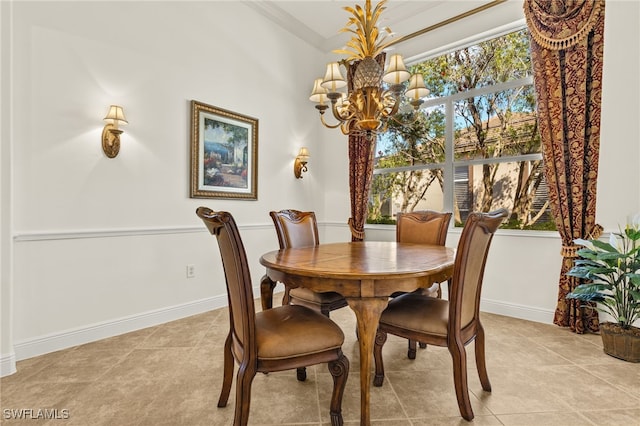 dining area with a chandelier, crown molding, baseboards, and light tile patterned flooring