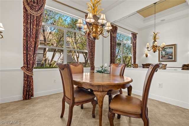 dining area featuring an inviting chandelier, crown molding, baseboards, and a raised ceiling