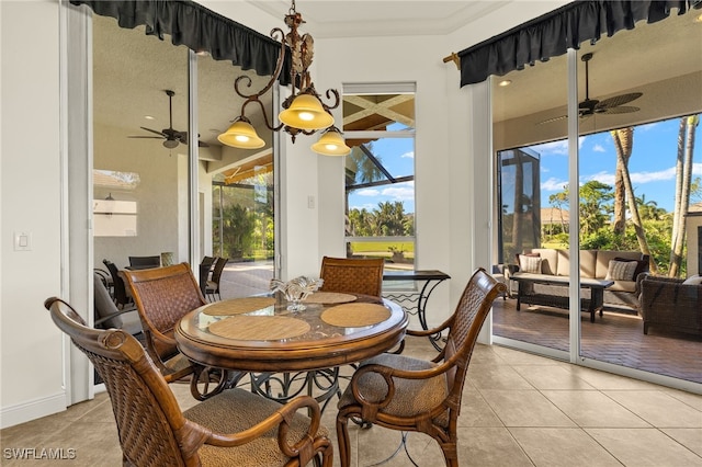 dining room with a wealth of natural light, light tile patterned flooring, a ceiling fan, and a sunroom