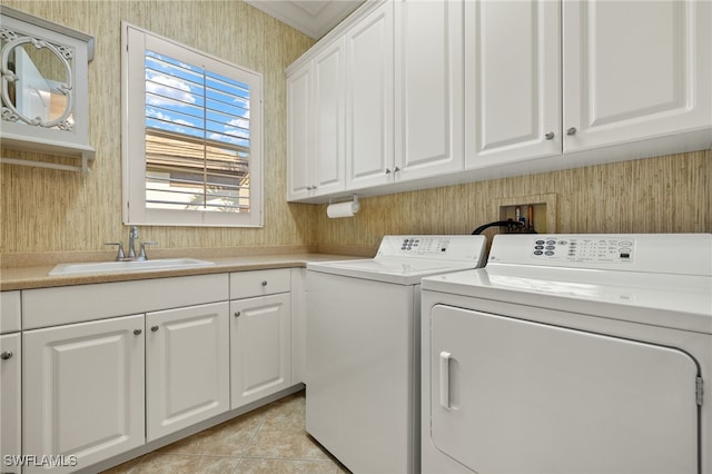 laundry room with light tile patterned floors, cabinet space, independent washer and dryer, and a sink