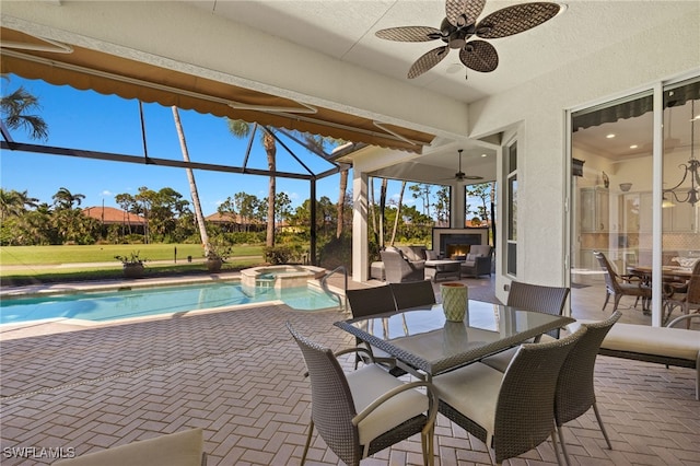 view of patio with outdoor dining space, glass enclosure, an outdoor living space with a fireplace, a pool with connected hot tub, and ceiling fan