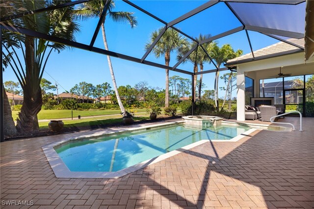 18270 Creekside View Dr, Fort Myers, FL 33908 - view of swimming pool with glass enclosure, a ceiling fan, a yard, a pool with connected hot tub, and a patio area
