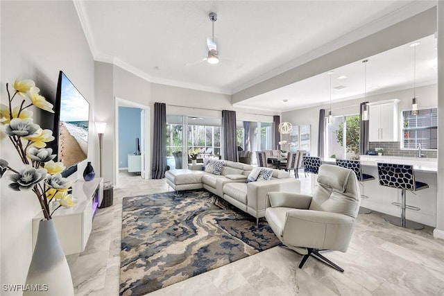 living room with a healthy amount of sunlight, marble finish floor, ceiling fan, and ornamental molding