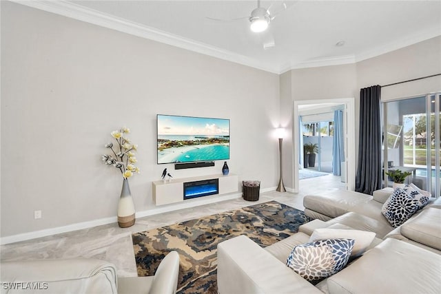 living room with ceiling fan, ornamental molding, a glass covered fireplace, and baseboards