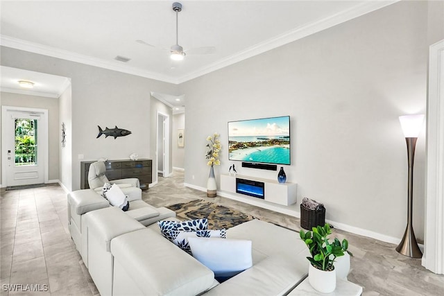 living area featuring baseboards, ceiling fan, visible vents, and crown molding