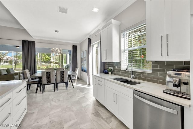 kitchen featuring visible vents, backsplash, stainless steel dishwasher, white cabinets, and a sink