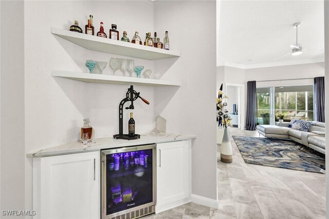 bar with a dry bar, crown molding, wine cooler, and a ceiling fan