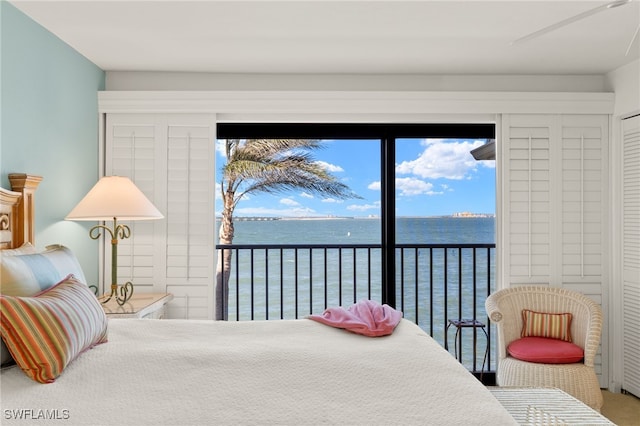 bedroom with a water view and access to outside