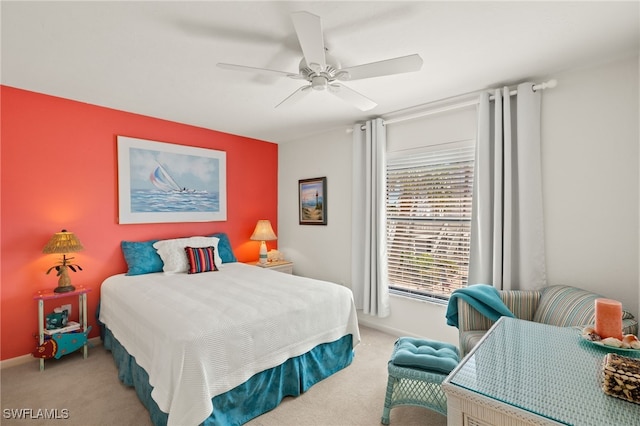 bedroom featuring light colored carpet, baseboards, and ceiling fan