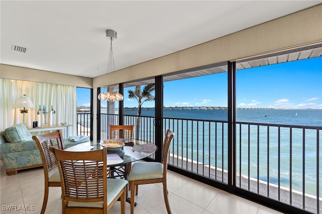 interior space with a notable chandelier, visible vents, and a water view